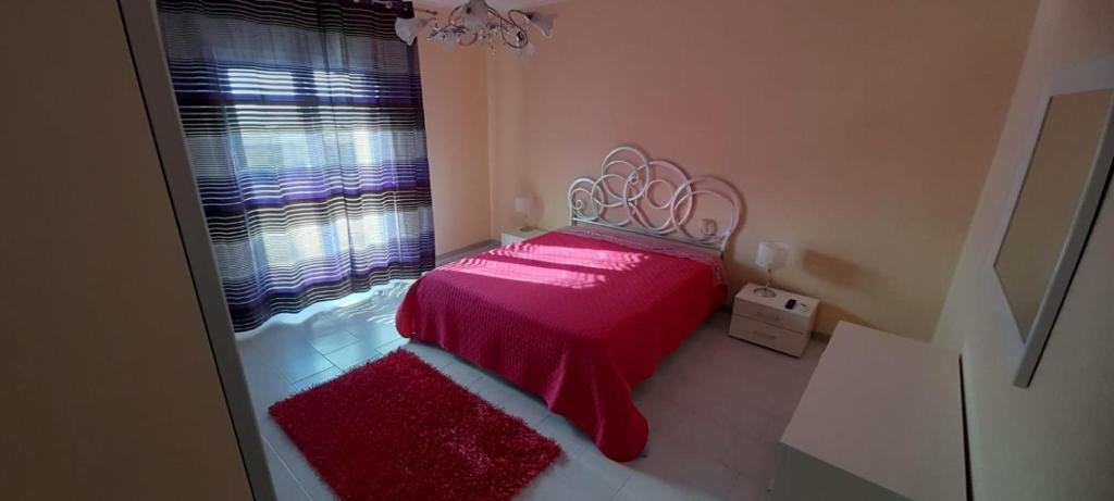 a small bedroom with a red bed with a window at Principessa e ranocchio in Custonaci