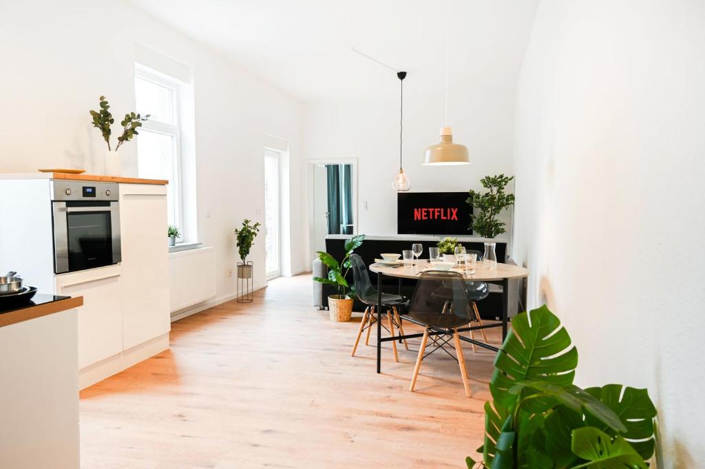 eine Küche und ein Esszimmer mit einem Tisch und Stühlen in der Unterkunft 50qm Apartment in Krefeld zentral gelegen mit hohen Decken - BEUYS Apartments - Krefeld in Krefeld