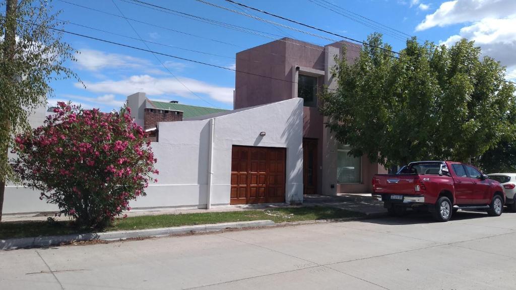 a red truck parked in front of a house at Rincón Mágico in Trelew