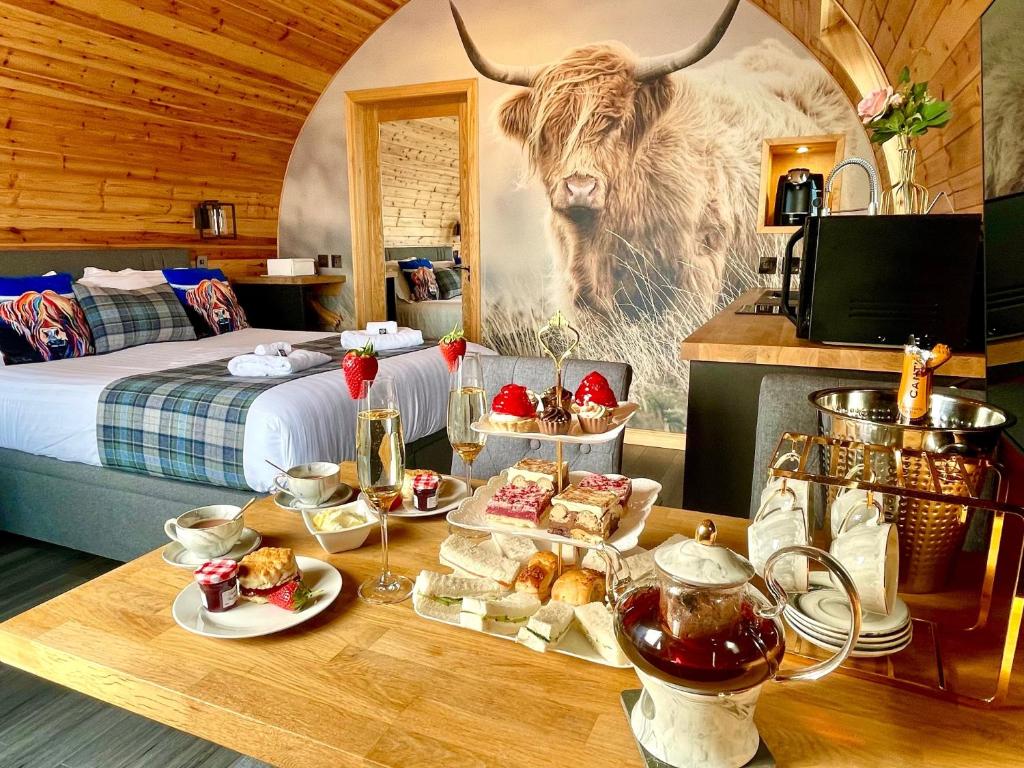 a room with a table with food and a cow on the wall at Pod 1, Sinclair bay lodges in Keiss