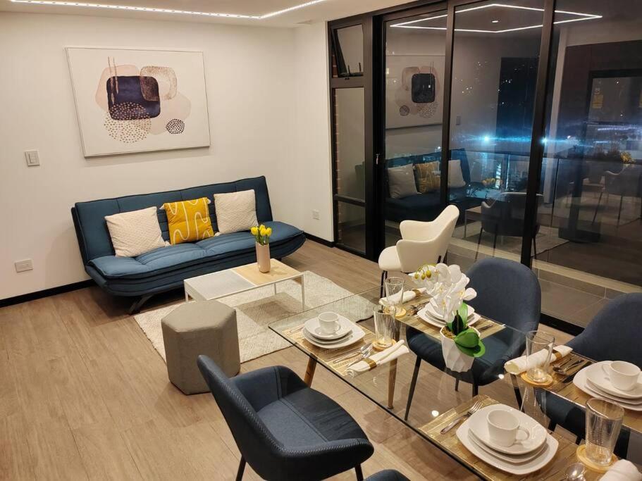 - un salon avec un canapé bleu et des chaises dans l'établissement Exclusivo, lujoso y nuevo apartamento en zona 10, à Guatemala