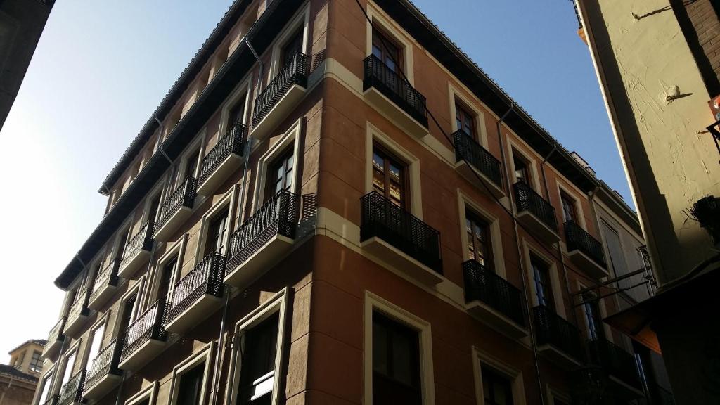 un edificio alto con balcones a un lado. en Apartamentos Ilíberis, en Granada