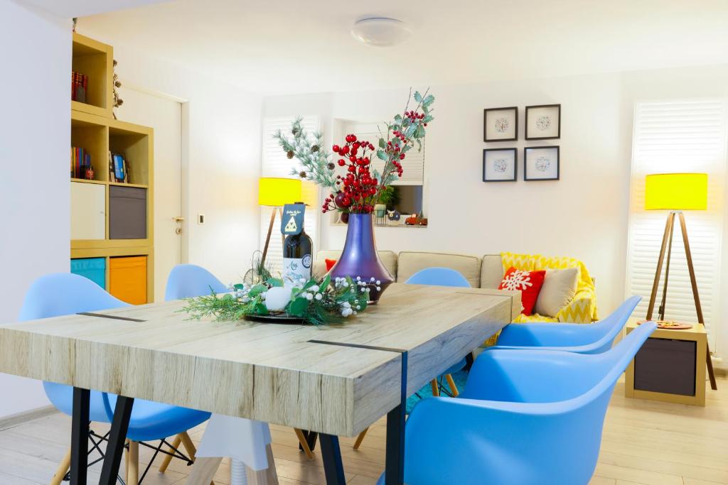 una sala da pranzo con tavolo in legno e sedie blu di Casa AVA a Straja