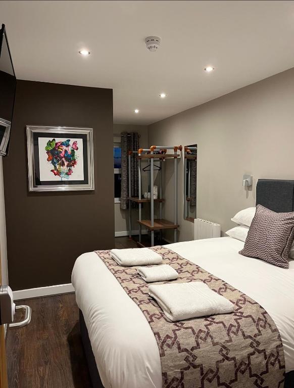 a bedroom with a large bed with pillows on it at The Vine Hotel Chapel st Leonards in Skegness