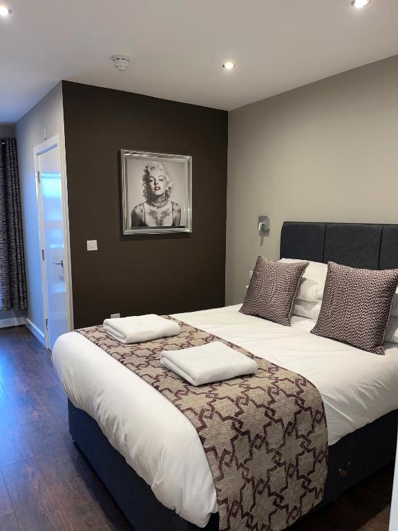 a bedroom with a large bed with two pillows on it at The Vine Hotel Chapel st Leonards in Skegness