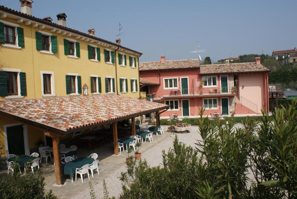 Blick auf ein Gebäude mit Tischen und Stühlen in der Unterkunft Corte Valesana in Lazise