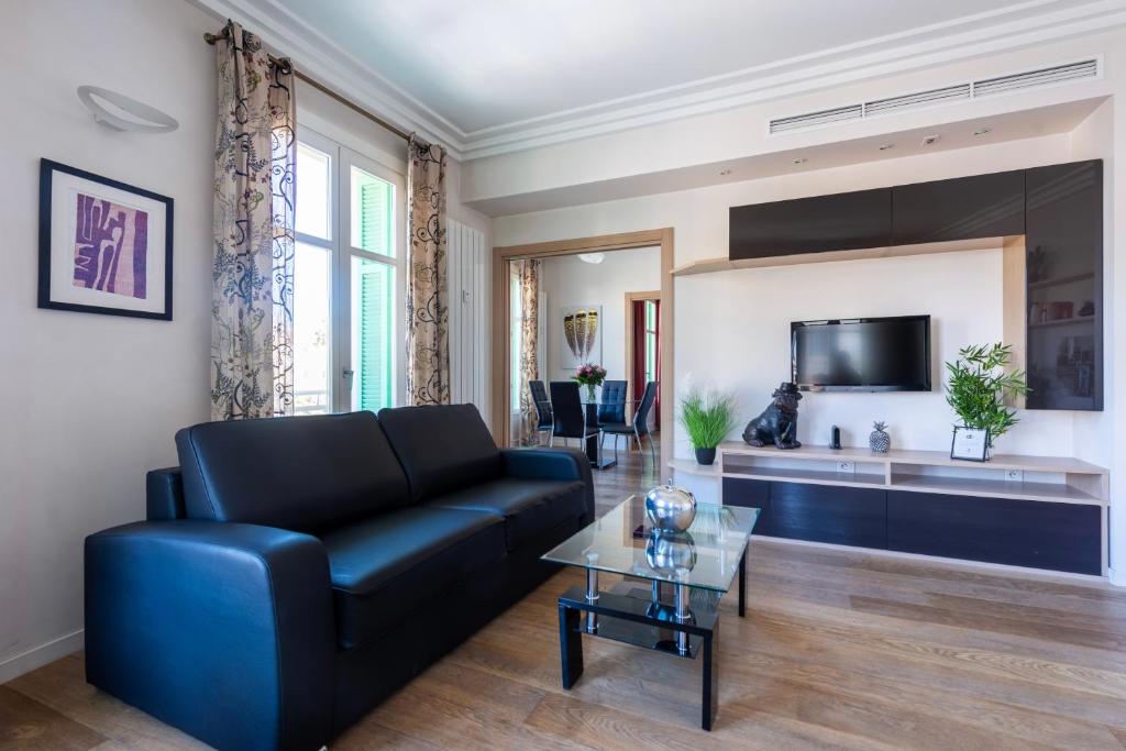 un salon avec un canapé bleu et une table dans l'établissement VICTOR HUGO - Modern and sunny, terrace, 2 baths, à Nice