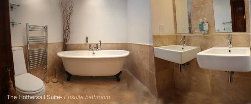 a bathroom with two sinks and a tub and a toilet at Riverside Barn in Ribchester