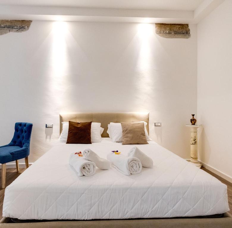 1 dormitorio con cama blanca y silla azul en CLASSIC FLAT boschetto, en Roma