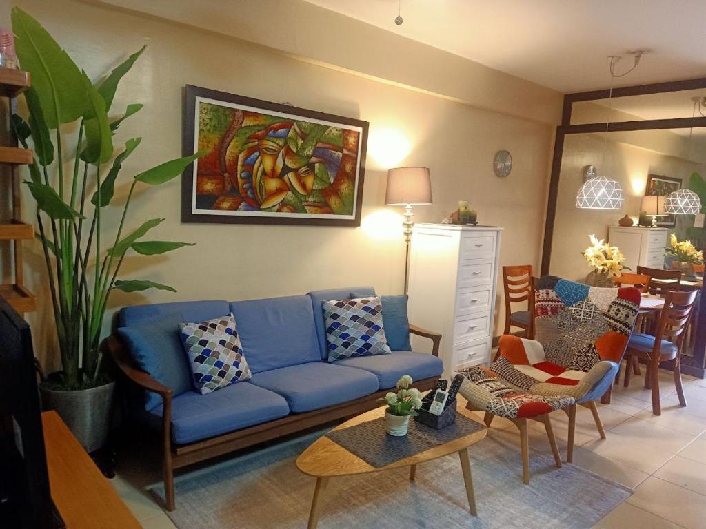 uma sala de estar com um sofá azul e uma mesa em The Redwoods Fairview Quezon City em Manila