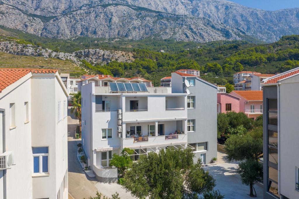 uma vista para um edifício com montanhas ao fundo em Apartmants Šestić em Tučepi