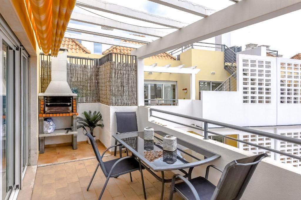 a balcony with a table and chairs in a room at Penthouse Cassia in Cabanas de Tavira