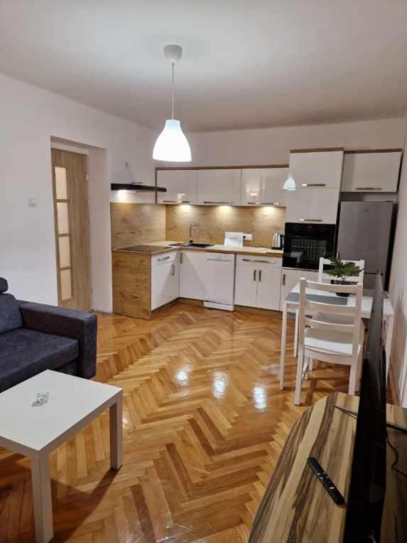 cocina y sala de estar con sofá y mesa en Apartament w Centrum, en Prudnik