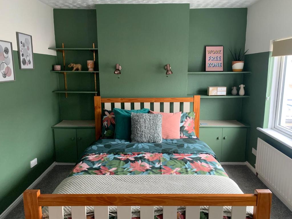 ein Schlafzimmer mit grünen Wänden und einem Holzbett in der Unterkunft La Brisa-fully refurbished, perfect local in Portrush