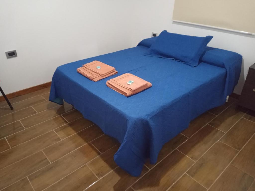 dos toallas están sentadas en una cama azul en Deptos La Punta en La Punta