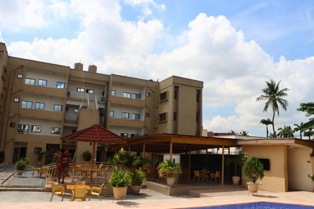 a hotel with a patio with tables and chairs at Presken Residence in Ikeja