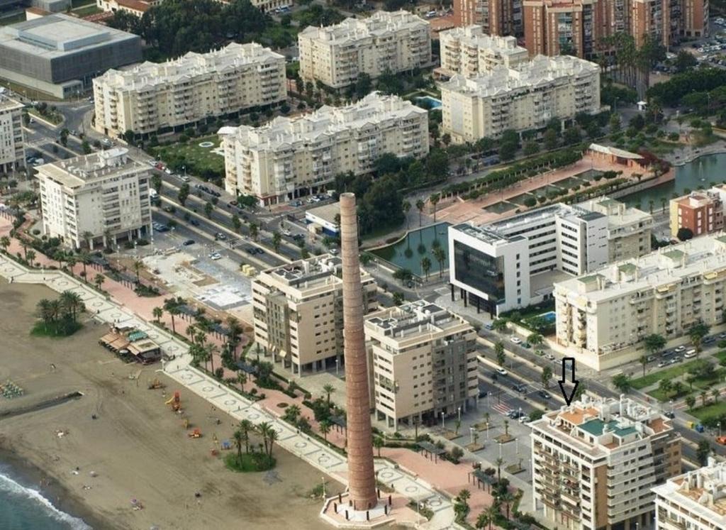 een luchtzicht op een stad met een hoge schoorsteen bij Paseo Marítimo Antonio Banderas in Málaga