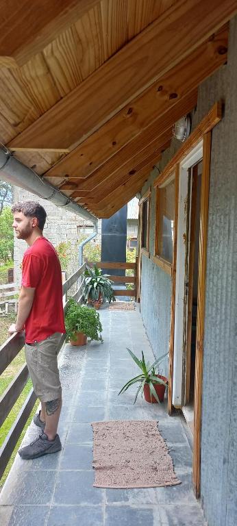 un hombre parado en el porche de una casa en Casa Típica Fueguina- Departamento 2 y 3 en Ushuaia