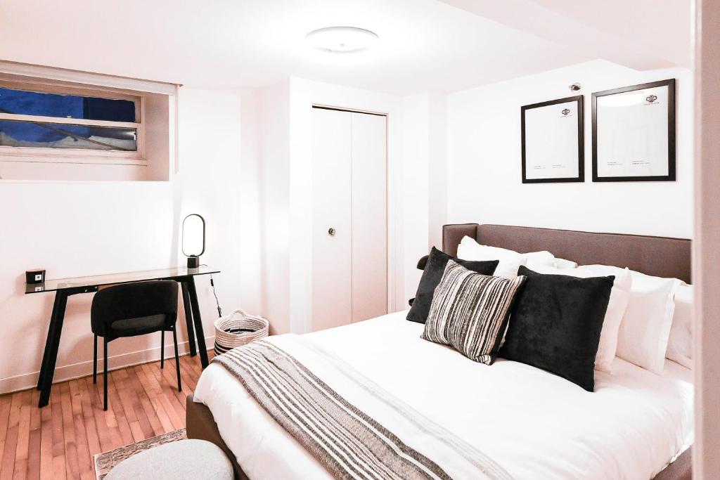 a white bedroom with a bed and a desk at Amazing Location in Old Quebec - 1br Condo in Quebec City