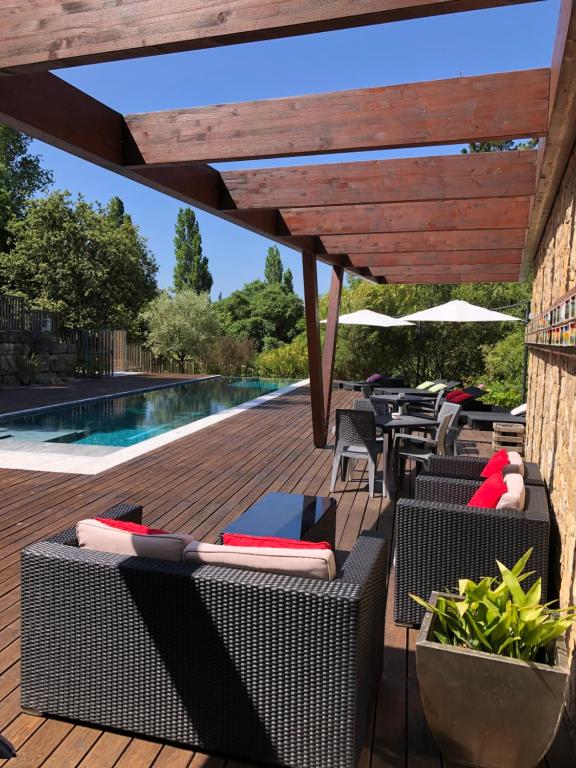 una terrazza con sedie e tavoli e una piscina di Casas Dos Infantes - Turismo Rural a Caldas da Rainha