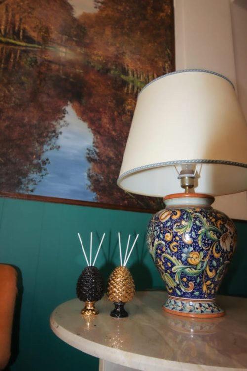 Una lámpara en una mesa con dos conejitos. en Hotel dei Nebrodi, en Cesarò