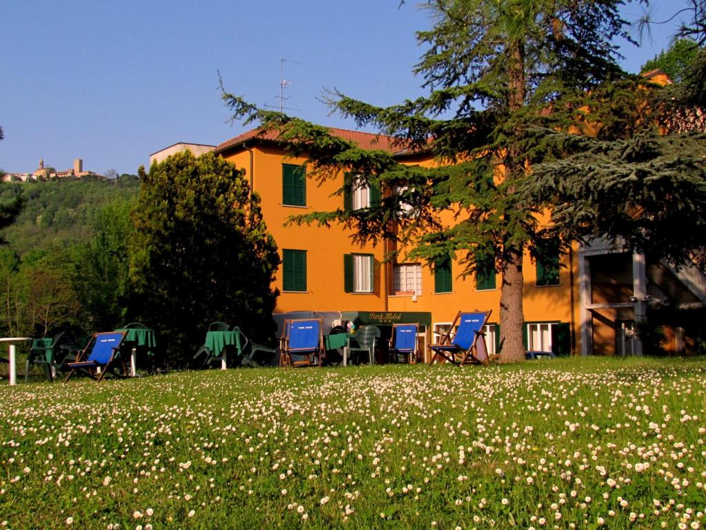 a house with chairs and tables in a field of flowers at Park Hotel Salice Terme - OltrePò Pavese - in Salice Terme