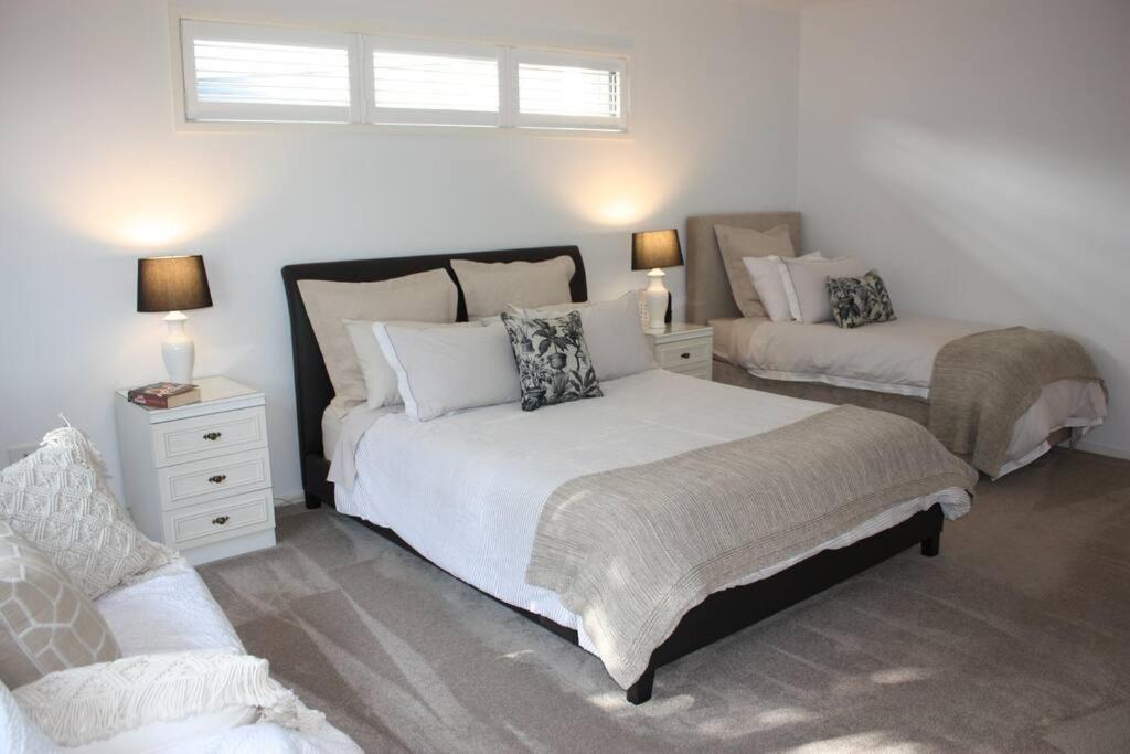 um quarto com 2 camas e um sofá em Little Haven in Mount Eliza with views em Mount Eliza