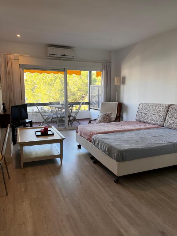 1 dormitorio con 1 cama y sala de estar con mesa en Estudio Marbella, en Marbella