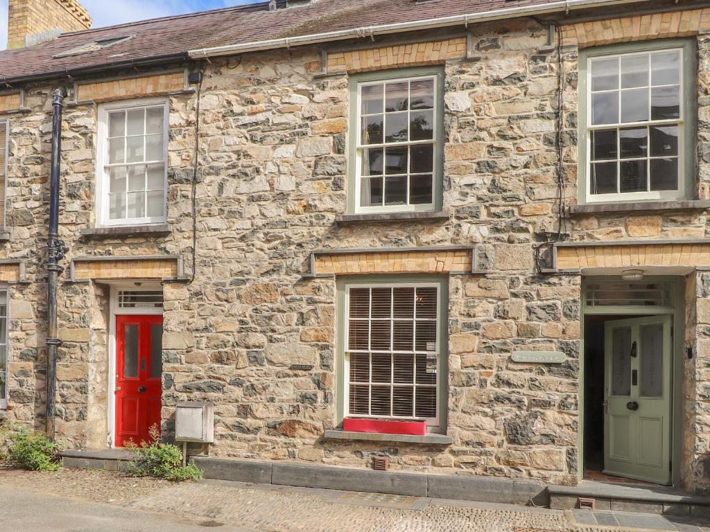 an old stone building with red doors and windows at Carnorfa in Newport Pembrokeshire