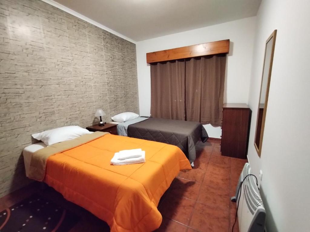 una camera d'albergo con due letti e una televisione di Apartamentos Lisboa a Vila do Porto