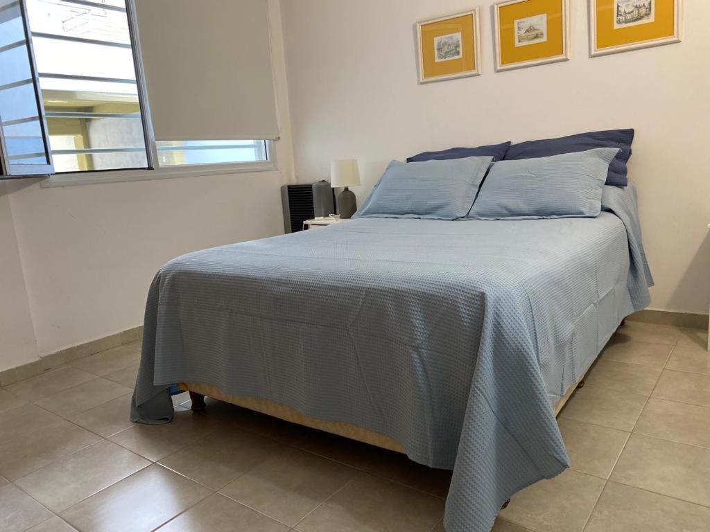 a bedroom with a bed with a blue comforter at Muy lindo departamento! in Puerto Madryn