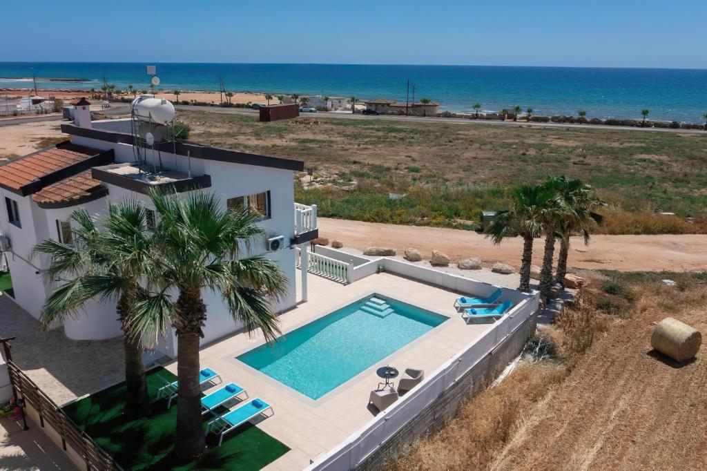 an aerial view of a house with a swimming pool and the beach at Villa suncity Boutique Beachfront in Ayia Napa