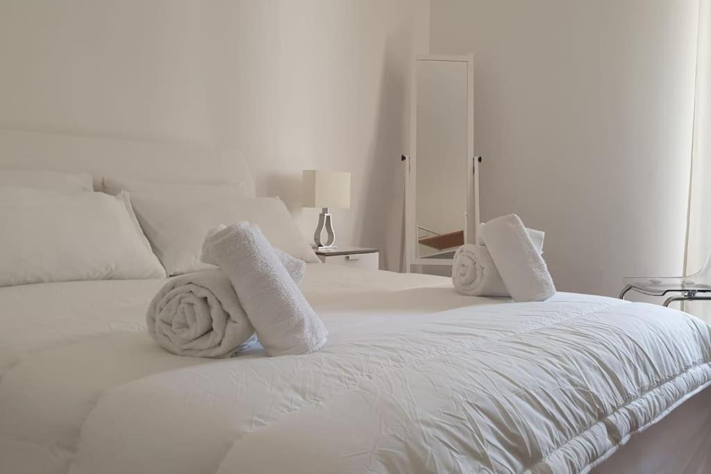 a white bed with towels on top of it at Appartamento Teatro Massimo in Catania