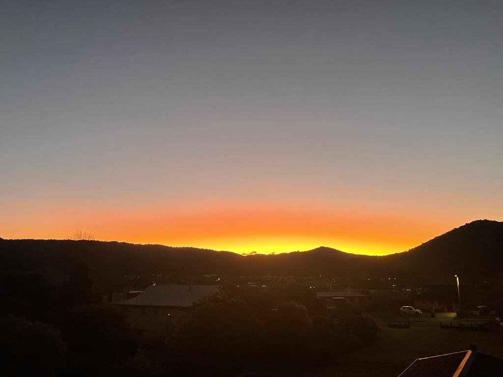 Moana BnB, Waikawa Bay, Picton في Waikawa: غروب الشمس على مدينة فيها جبال في الخلفية