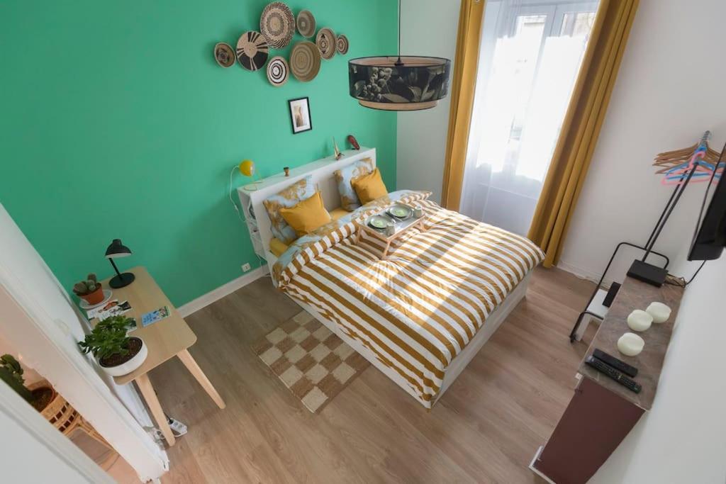 um pequeno quarto com uma cama e uma mesa em La Station 44 - quartier Canclaux em Nantes