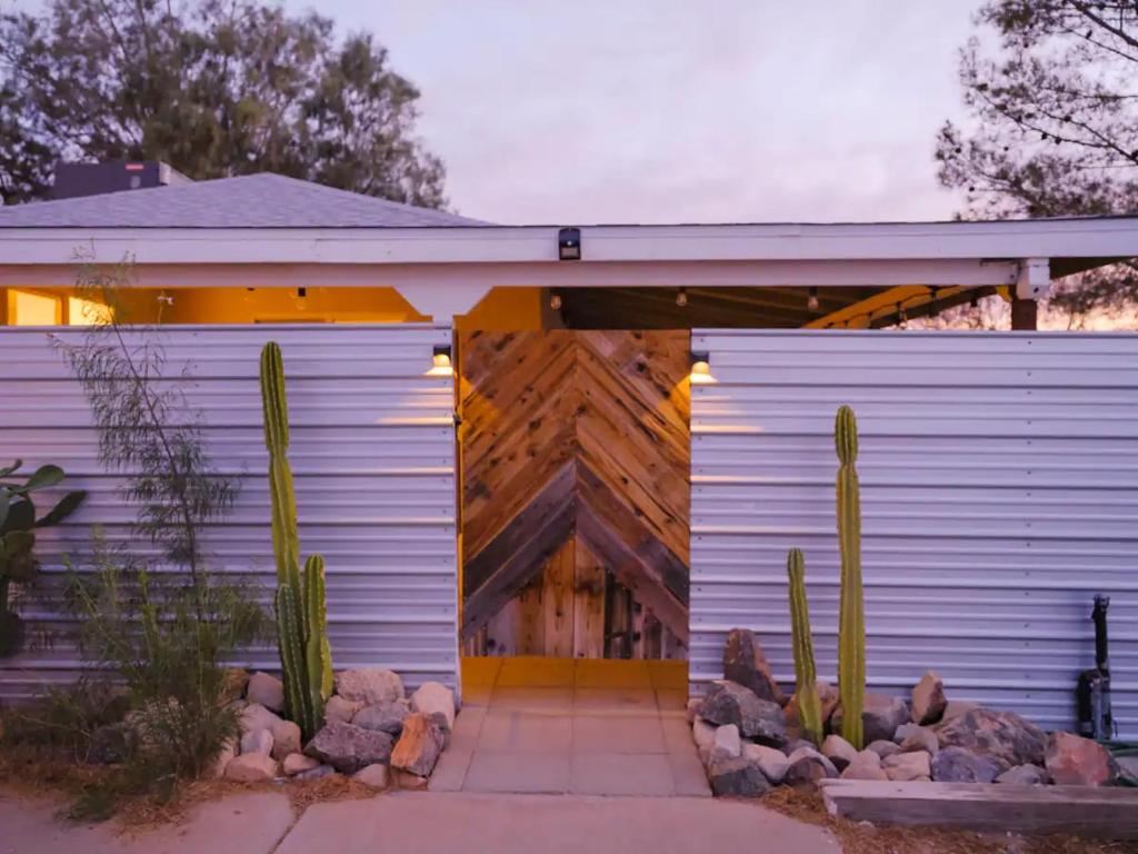 ein Haus mit Kaktus davor in der Unterkunft The Zen - Outdoor Shower, Gas Fireplace, Walkable to Shops & Restaurants in Joshua Tree