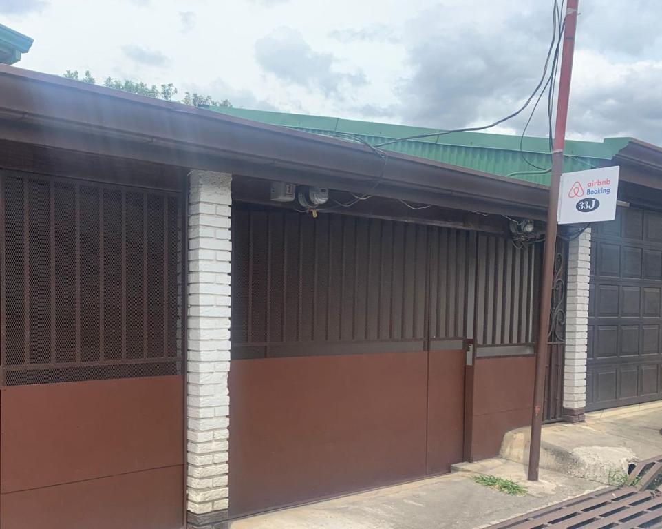 ein Gebäude mit einem Tor und einem Schild darauf in der Unterkunft Alojamiento entero 1 km Juan Santamaría Airport in Alajuela
