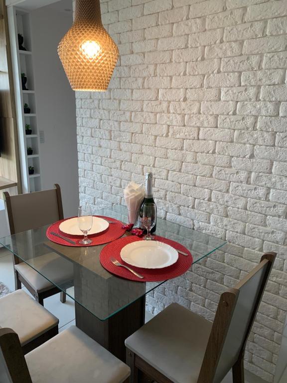uma mesa de jantar com 2 pratos e uma garrafa de vinho em Apartamento completo Ilheus em Ilhéus