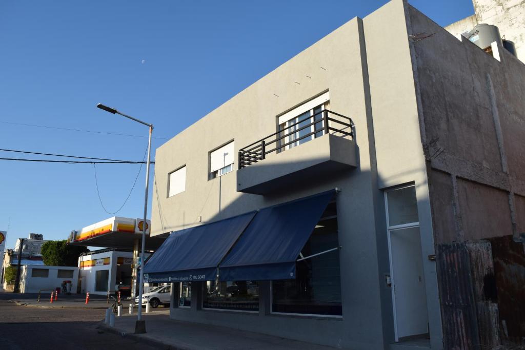 un edificio con un toldo azul a su lado en La Recalada Departamentos en Concepción del Uruguay