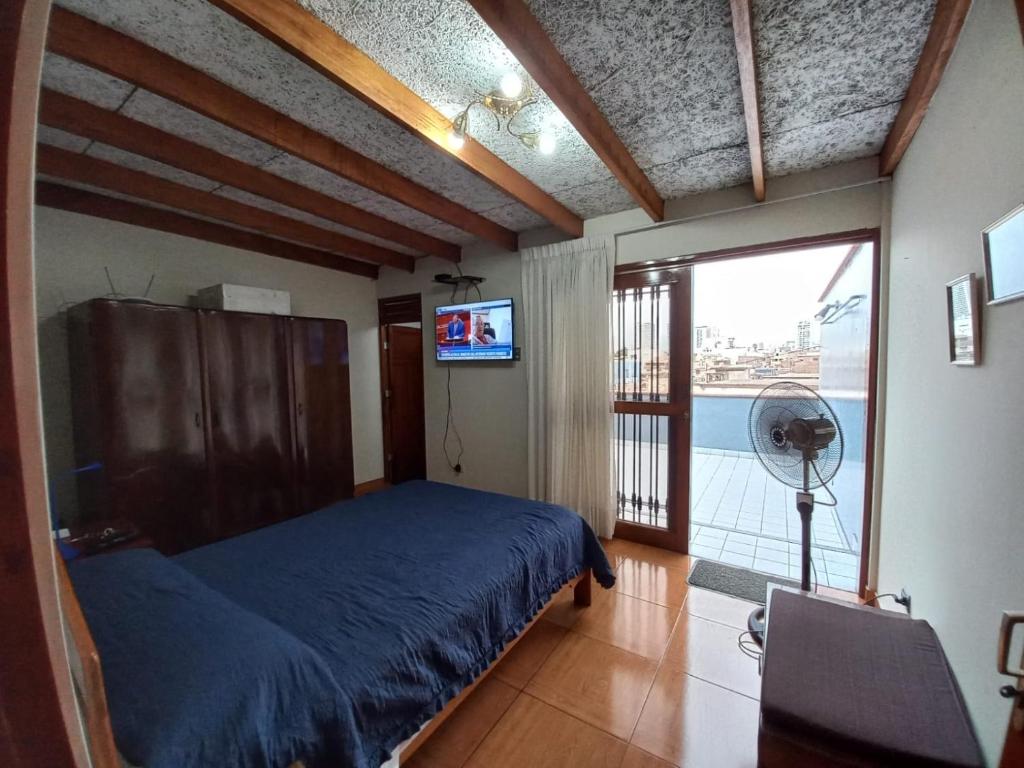 um quarto com uma cama, uma televisão e uma janela em Mini depa en centro histórico de Pueblo Libre em Lima