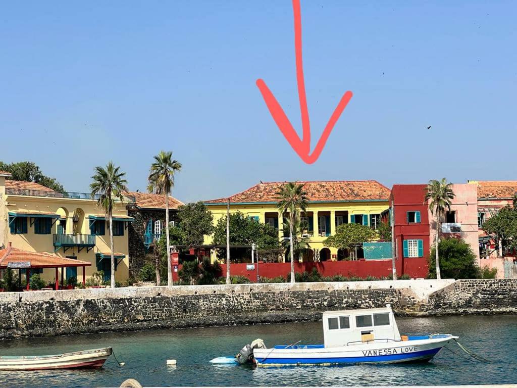 戈雷島的住宿－Chez Olivier - Île de Gorée，船在水中靠近一些建筑物