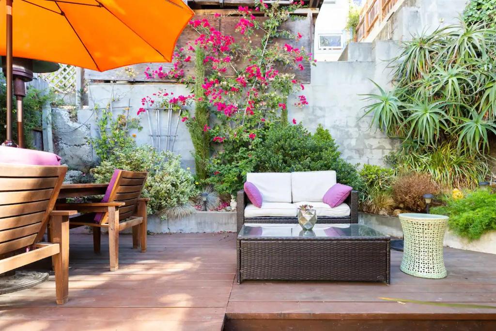 舊金山的住宿－Beautiful Condo in Sun Drenched Garden，天井配有椅子和带雨伞的桌子