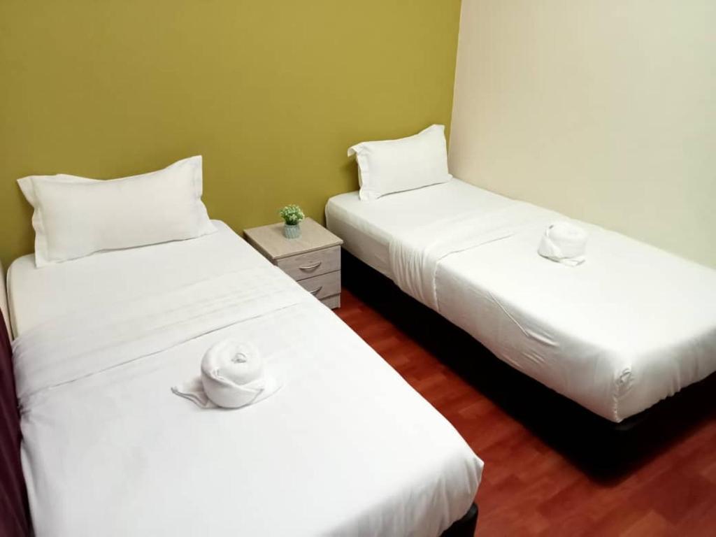 two beds in a room with white sheets at Aeropod Hostel Economy Twin Room in Kapayan