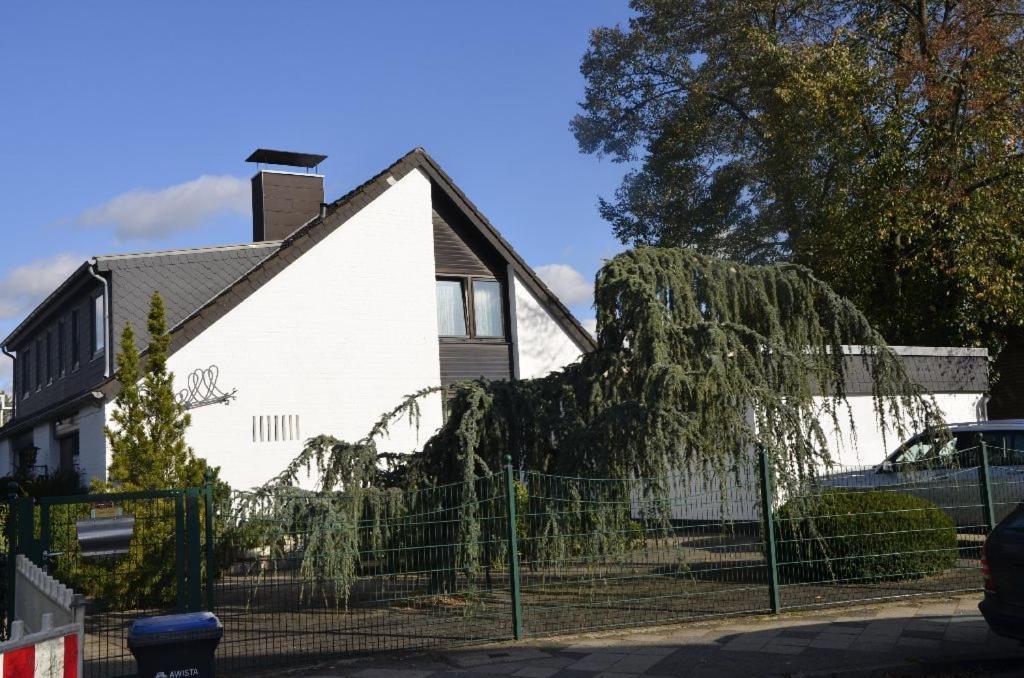 ein weißes Haus mit einem Zaun davor in der Unterkunft Guesthouse AirMinis in Düsseldorf