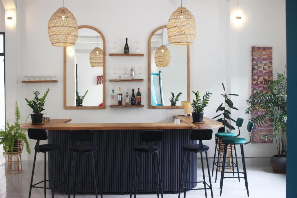 a bar in a room with stools and mirrors at Baan Pila in Luang Prabang