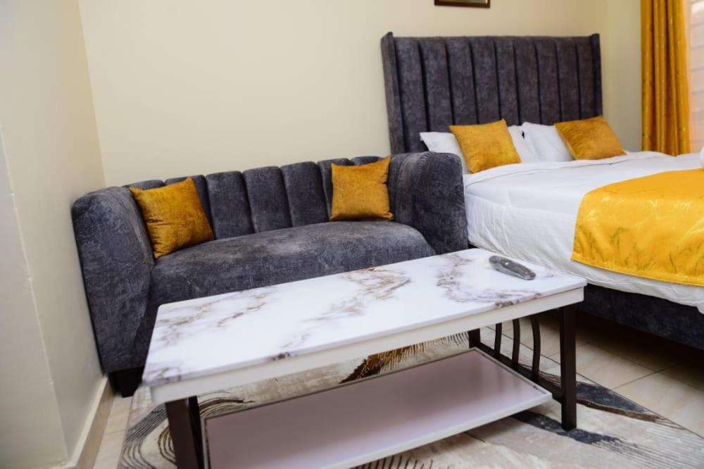 a bedroom with a couch next to a bed at Elegant studio apartment in Kitengela 