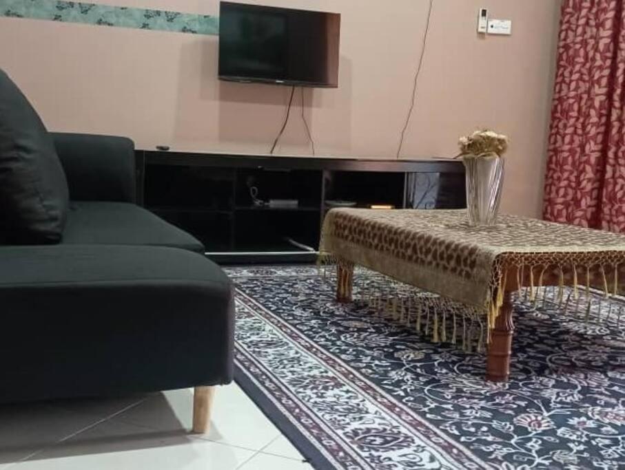 a living room with a couch and a table and a tv at Nafili homestay 3bd 2br in Kota Bharu