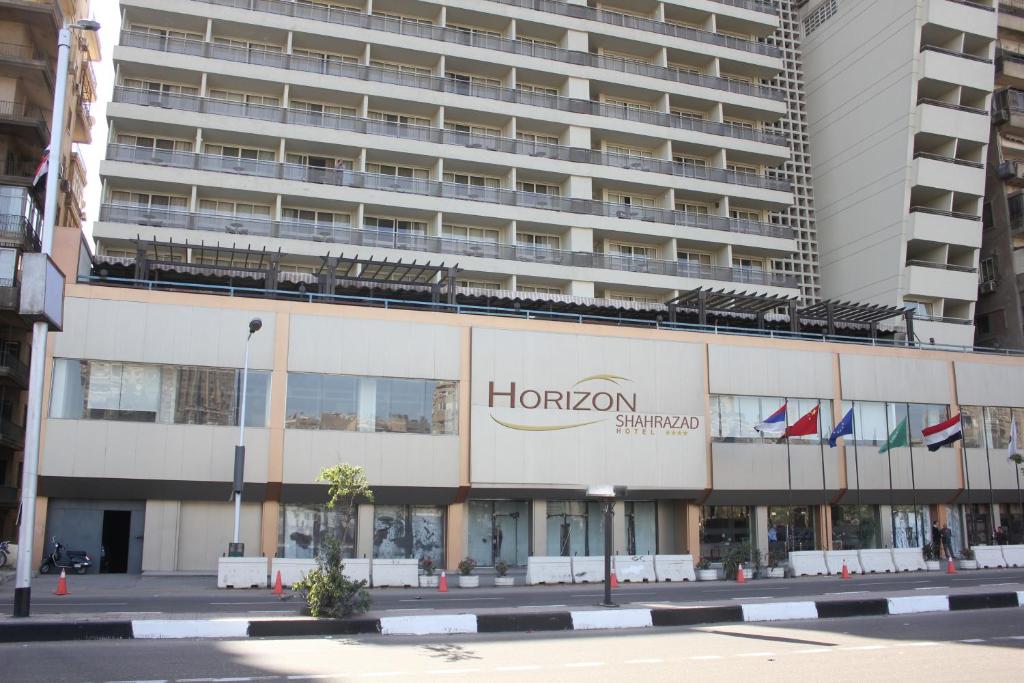 een groot gebouw met een hogan bord ervoor bij Horizon Shahrazad Hotel in Caïro