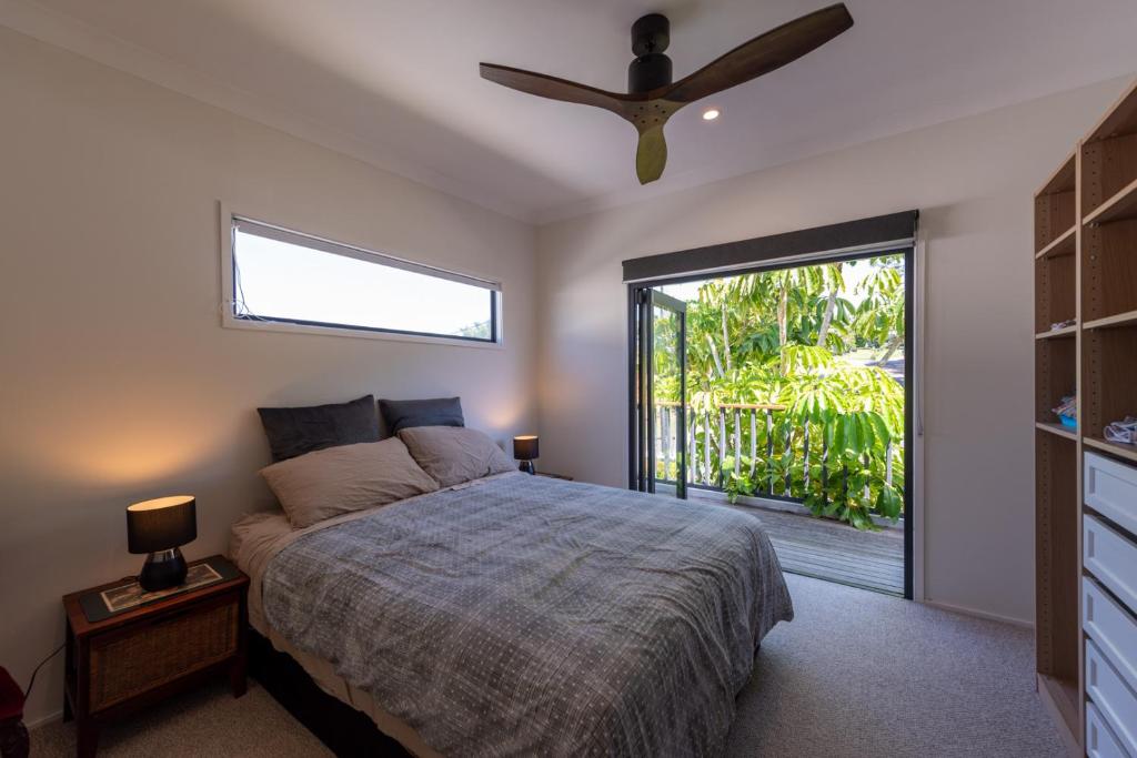 a bedroom with a bed and a ceiling fan at Central Coast-Spacious House 5 minutes drive to beach in Tumbi Vmbi