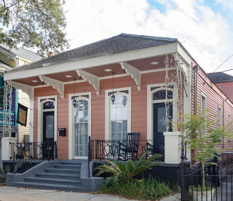 a small pink house with a porch and stairs at Beautifully Updated New Orleans House *sleeps 6* in New Orleans